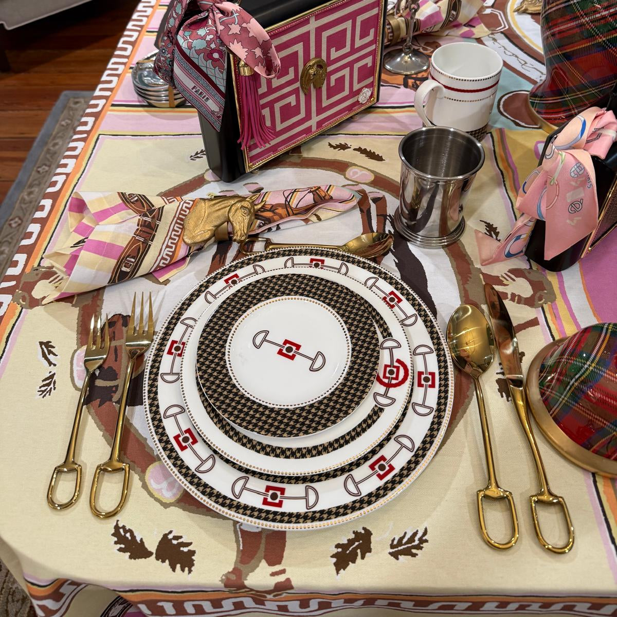 Decorative table setting with a patterned tablecloth, plates, and cutlery.